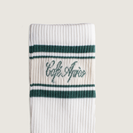 Load image into Gallery viewer, White sock with green stripes and 'Cafe Apres' text on a beige background