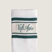 White sock with green stripes and 'Cafe Apres' text on a beige background