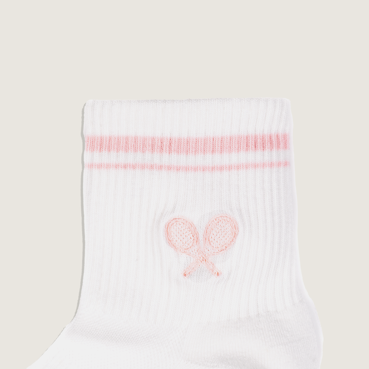 White socks with pink embroidered design on a beige background