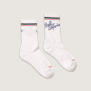 White socks with green and red accents on a light gray background with Café Après logo in blue