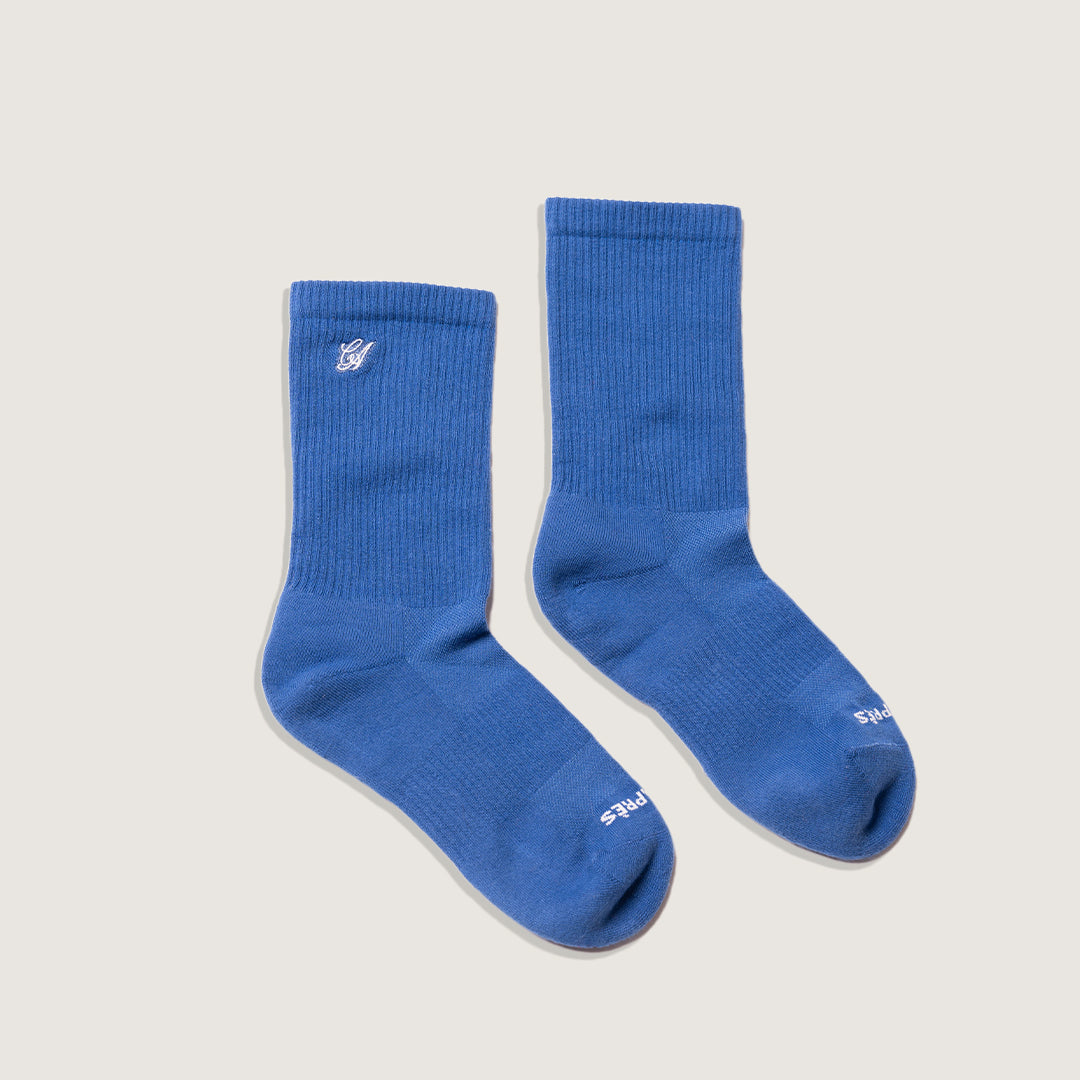 Pair of blue socks on a light gray background