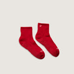 Load image into Gallery viewer, Pair of red socks with grip on a light gray background
