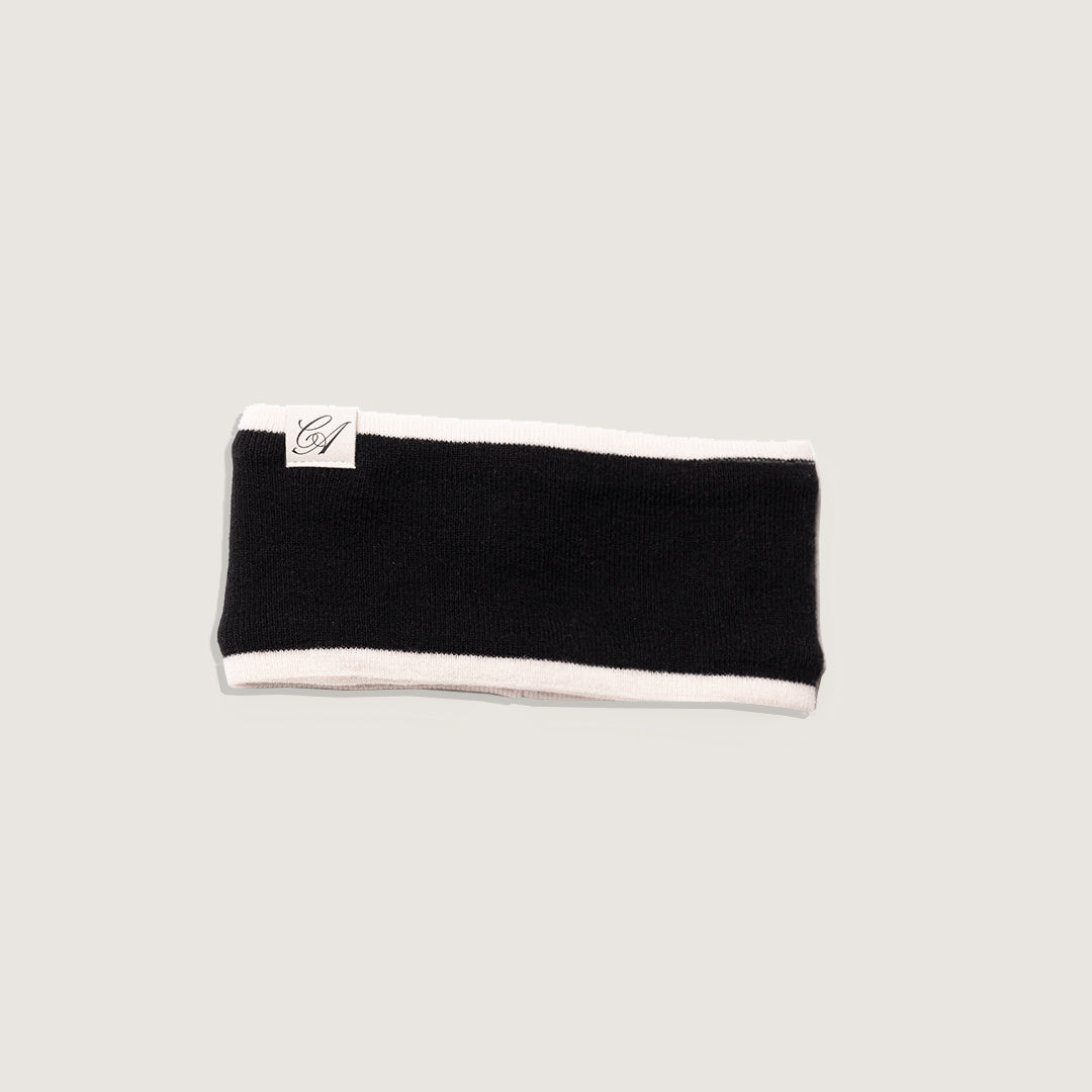 Black headband with white trim on a light gray background