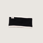 Black headband with white trim on a light gray background