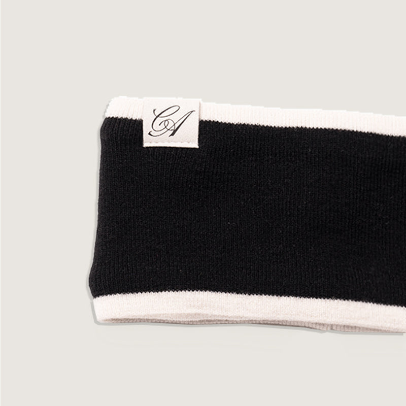 Black and white headband with a brand logo on a light gray background