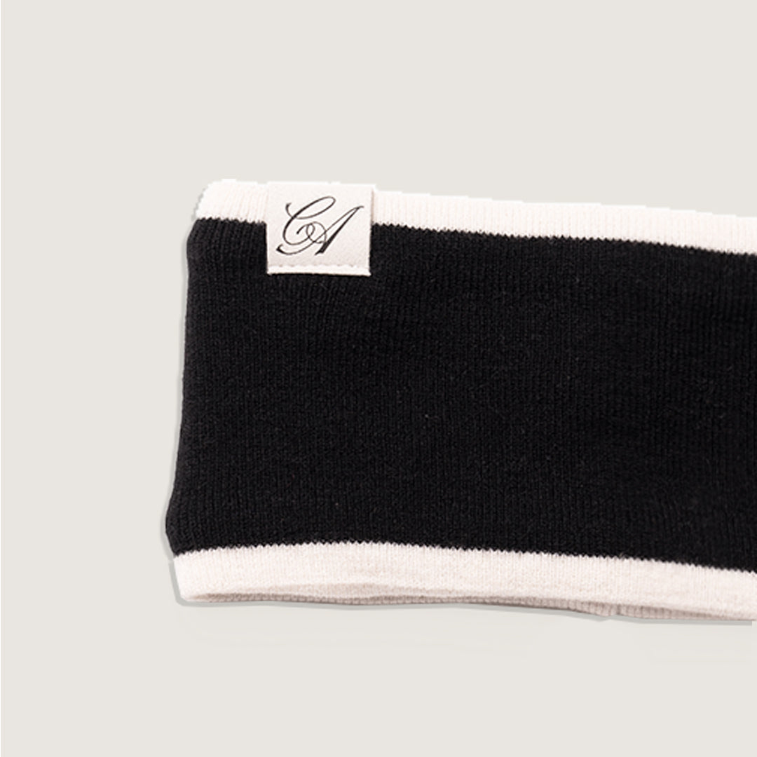 Black and white headband with a brand logo on a light gray background