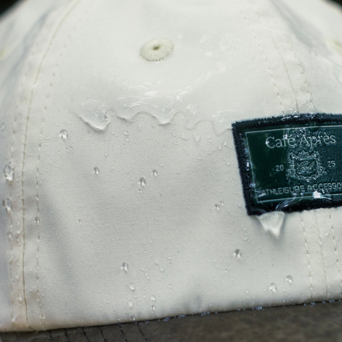 White cap with water droplets and a visible brand label on a blurred background