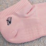 Load image into Gallery viewer, Pink sock with a small CA design on a textured surface
