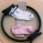 Load image into Gallery viewer, Martini grip socks and a pink ankle grip socks with a pilates circle with a beige background
